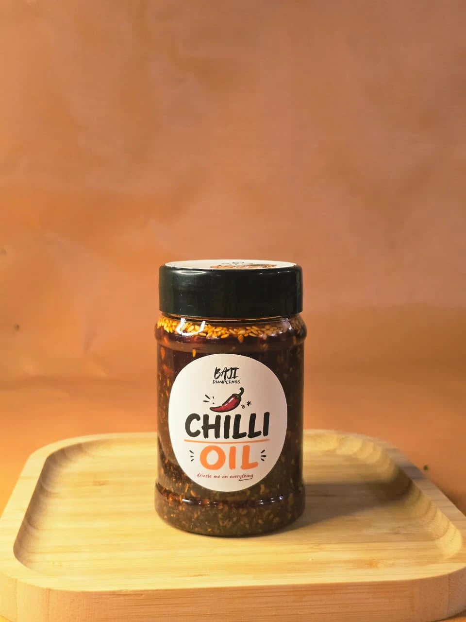 Baji Dumplings chilli oil jar on a wooden board