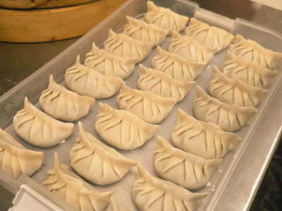 A tray of freshly hand-pleated dumplings