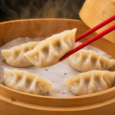 Chicken and chive dumplings steaming in a bamboo basket
